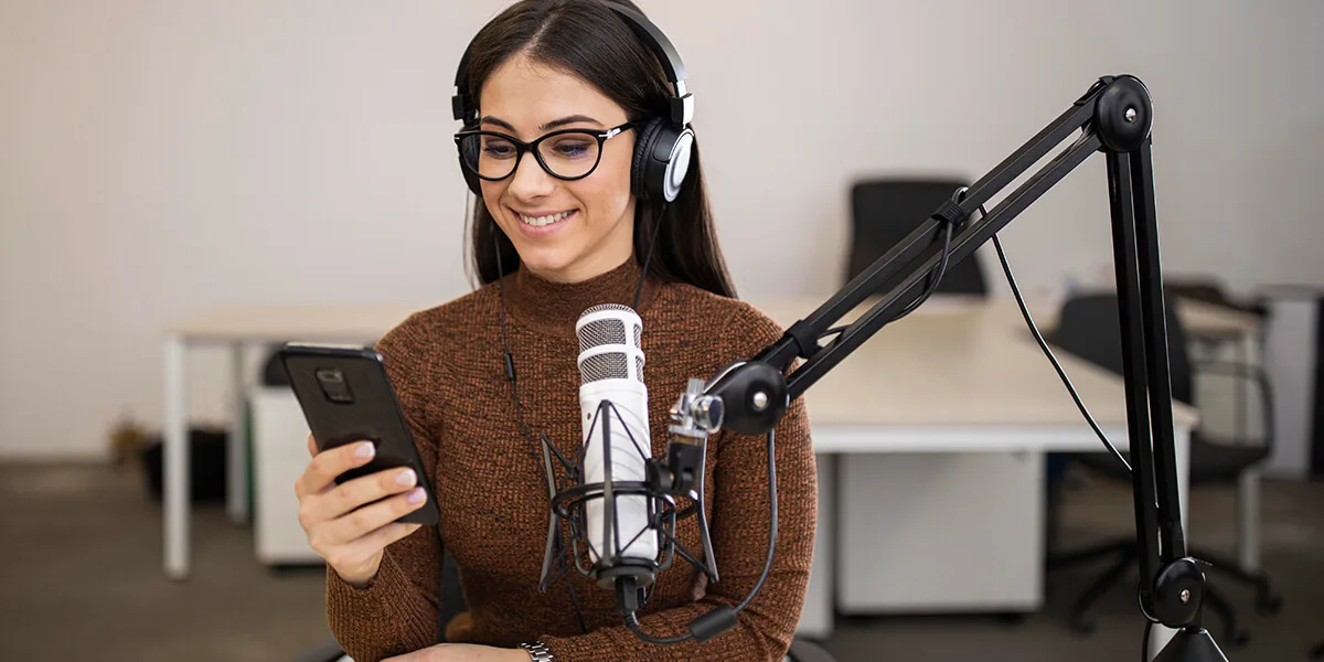 Person using microphone and smartphone.